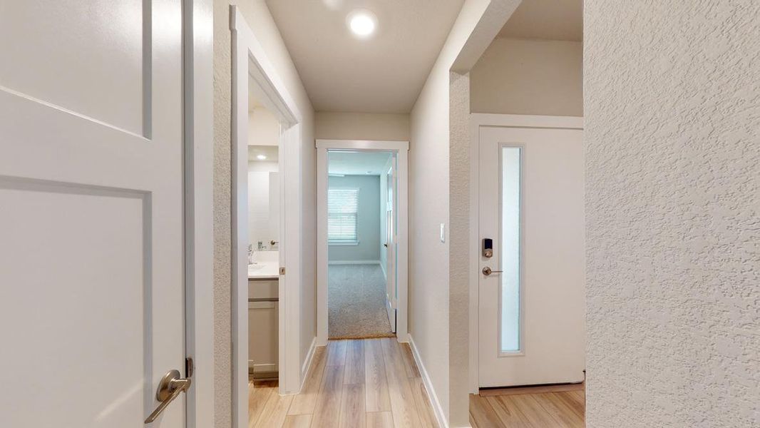 Corridor featuring light wood finished floors and baseboards