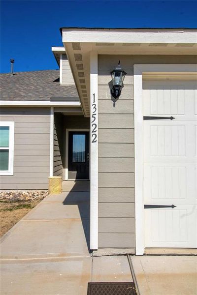 Doorway to property featuring a shingled roof