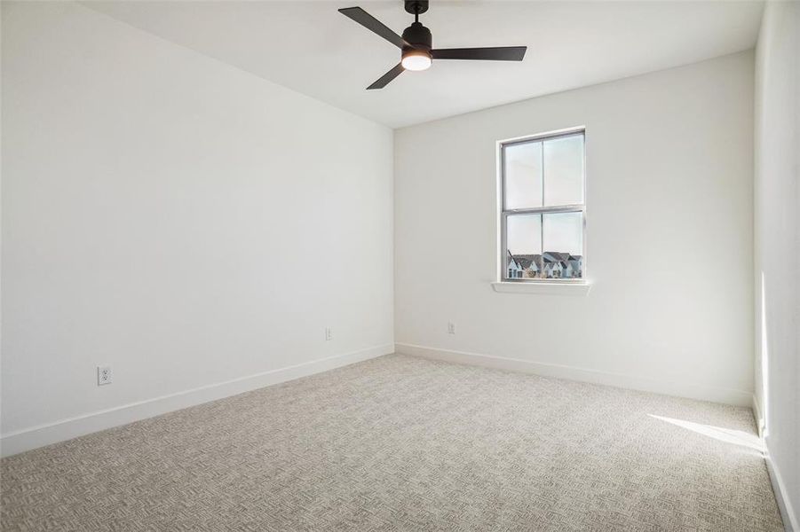 Unfurnished room featuring carpet floors and ceiling fan