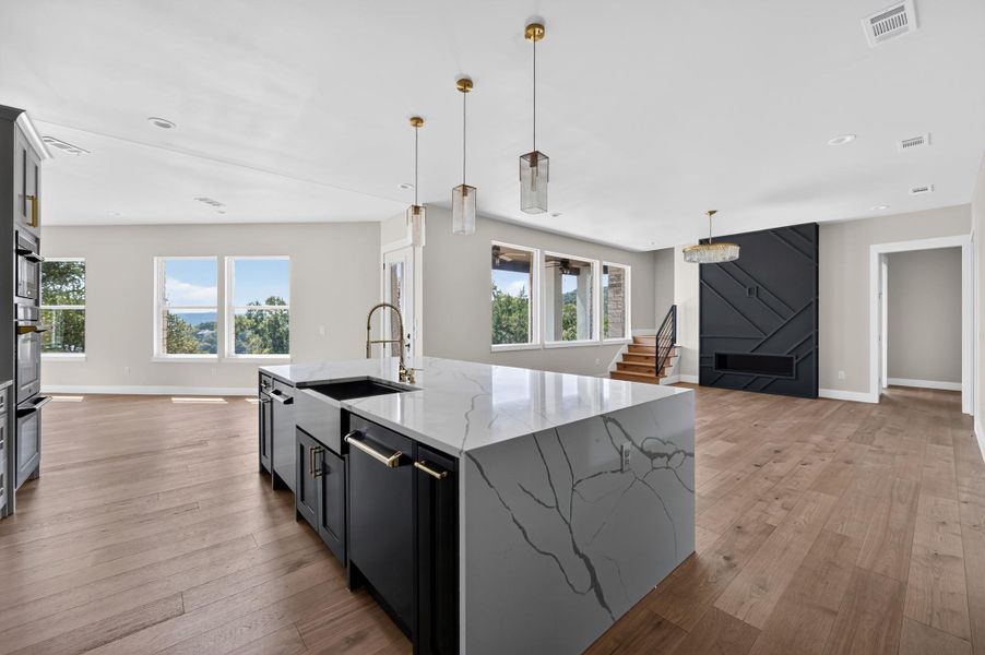 Gleaming hardwood floors and a spacious stone island anchor this open-concept main living space.