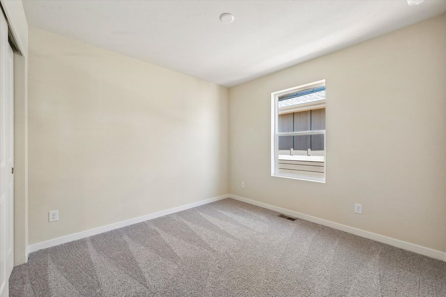 A room with a carpet and a window.