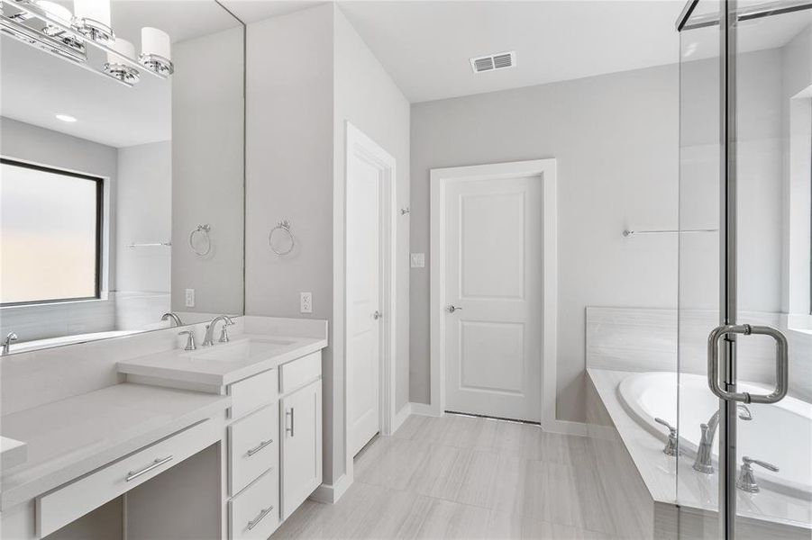 The primary bathroom is a luxurious retreat featuring a freestanding tub and an oversized walk-in shower. Elegant finishes and ample space create a serene and sophisticated atmosphere for ultimate relaxation.