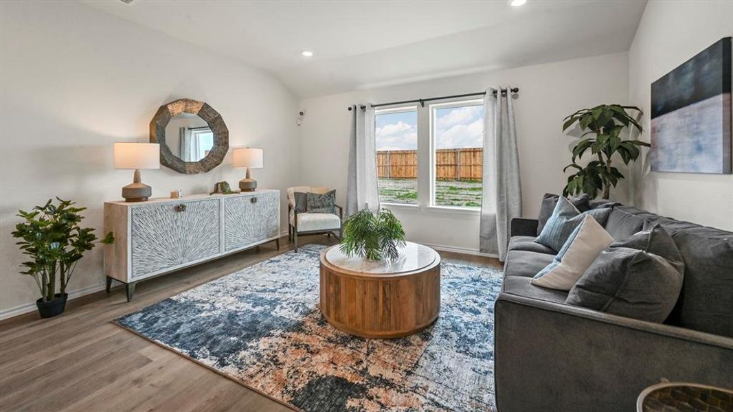 Sitting room featuring lofted ceiling, wood finished floors, and recessed lighting Sitting room featuring lofted ceiling, wood finished floors, and recessed lighting