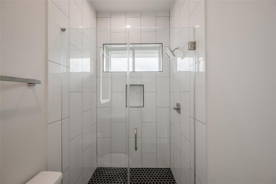 The glass fronted shower is spacious with a wide door for easy access.