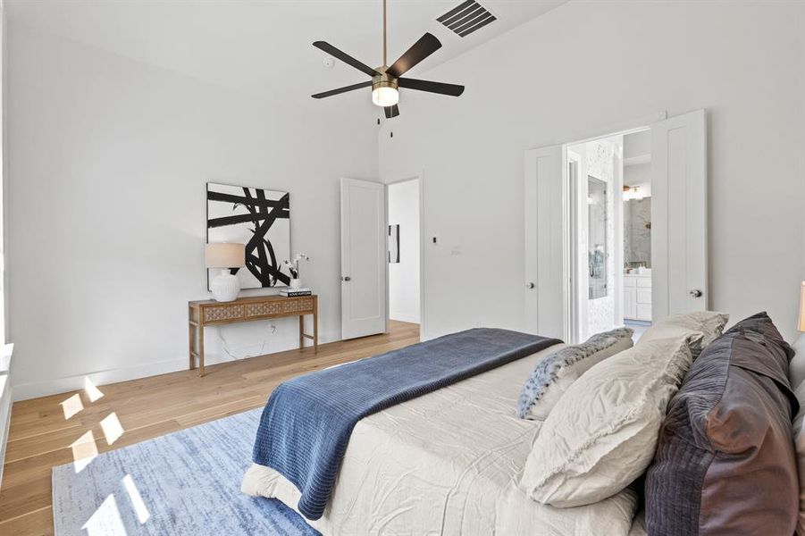 Bedroom with wood finished floors, a towering ceiling, and a ceiling fan
