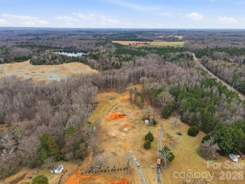 Aerial view of the lot - home will be positioned near the orange dirt in the center, or possibly behind it, closer to woods. Will have a paved driveway leading to the house. Aerial view of the lot - home will be positioned near the orange dirt in the center, or possibly behind it, closer to woods. Will have a paved driveway leading to the house.