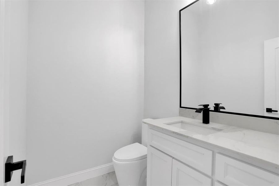 Bathroom featuring tile patterned flooring, toilet, and vanity