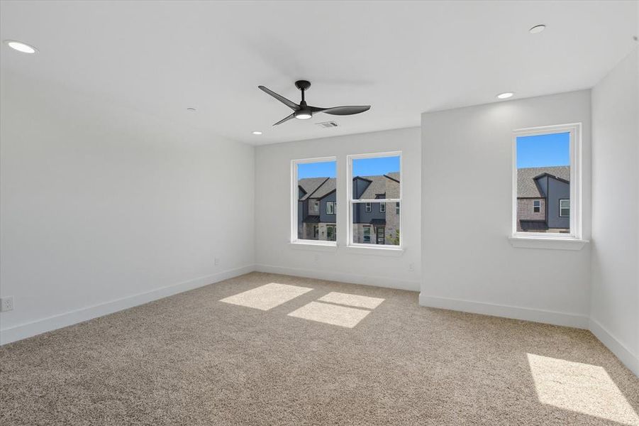 Primary bedroom with plenty of natural light, light carpet, a ceiling fan, and recessed lighting