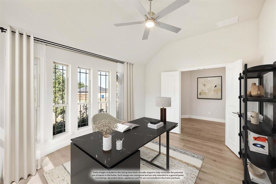 Home office with vaulted ceiling, black desk, ceiling fan, and large windows with natural light Home office with vaulted ceiling, black desk, ceiling fan, and large windows with natural light