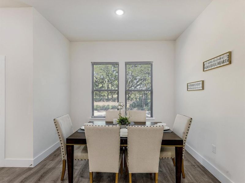 Dining space with wood finished floors and recessed lighting