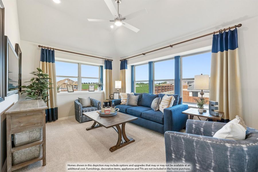 Living room with vaulted ceiling, blue sofa, ceiling fan, and large windows with outdoor views Living room with vaulted ceiling, blue sofa, ceiling fan, and large windows with outdoor views