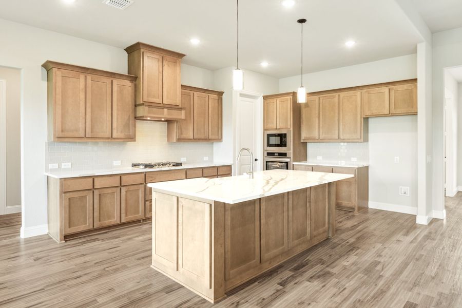 Kitchen with light wood cabinets, large center island with white quartz countertop, and hardwood floors Kitchen with light wood cabinets, large center island with white quartz countertop, and hardwood floors