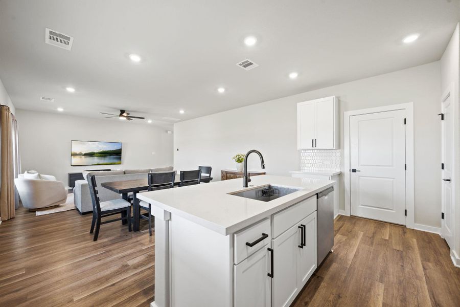 An open floorplan seamlessly connects the functional kitchen island to the inviting dining and living areas. An open floorplan seamlessly connects the functional kitchen island to the inviting dining and living areas.