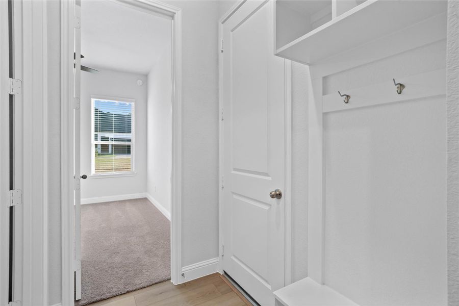 Step into this highly functional and stylish mudroom drop zone, an essential feature for a busy household. The space boasts custom-built white cabinetry and shelving, providing generous storage for coats, bags, and shoes. A comfortable built-in bench offers a convenient spot to sit, while three sleek hooks keep outerwear tidy and accessible. Step into this highly functional and stylish mudroom drop zone, an essential feature for a busy household. The space boasts custom-built white cabinetry and shelving, providing generous storage for coats, bags, and shoes. A comfortable built-in bench offers a convenient spot to sit, while three sleek hooks keep outerwear tidy and accessible.