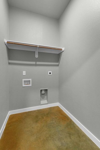 Functional utility room with ample space and essential hookups for laundry.