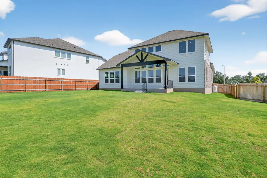 Back of property featuring a fenced backyard and a patio