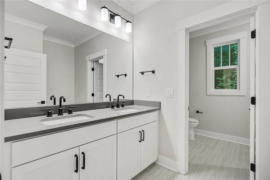 A clean, modern bathroom offers dual vanities with A clean, modern bathroom offers dual vanities with