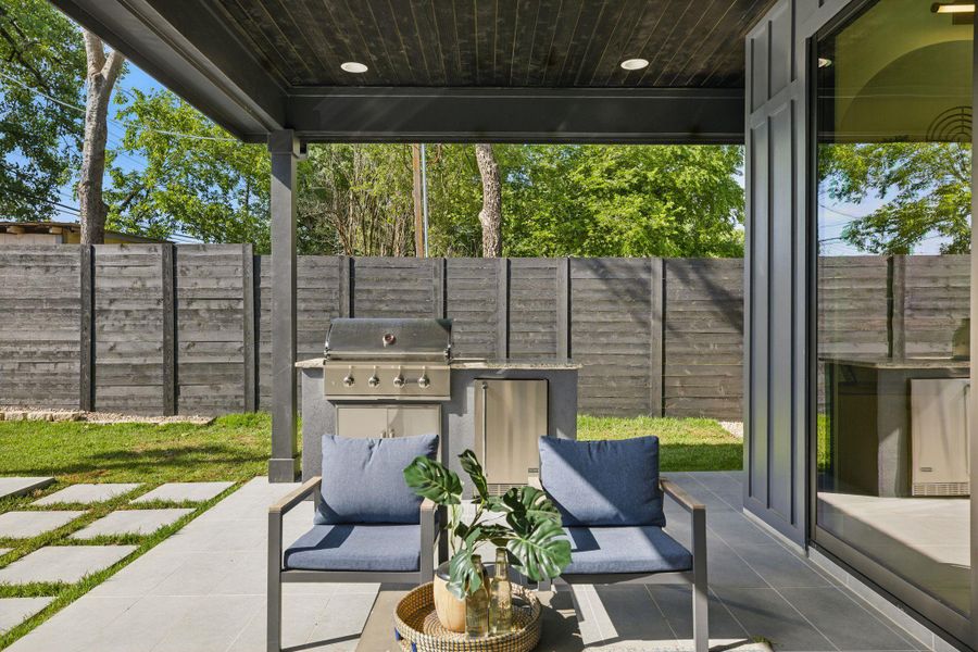Fenced backyard featuring a grill and a patio area