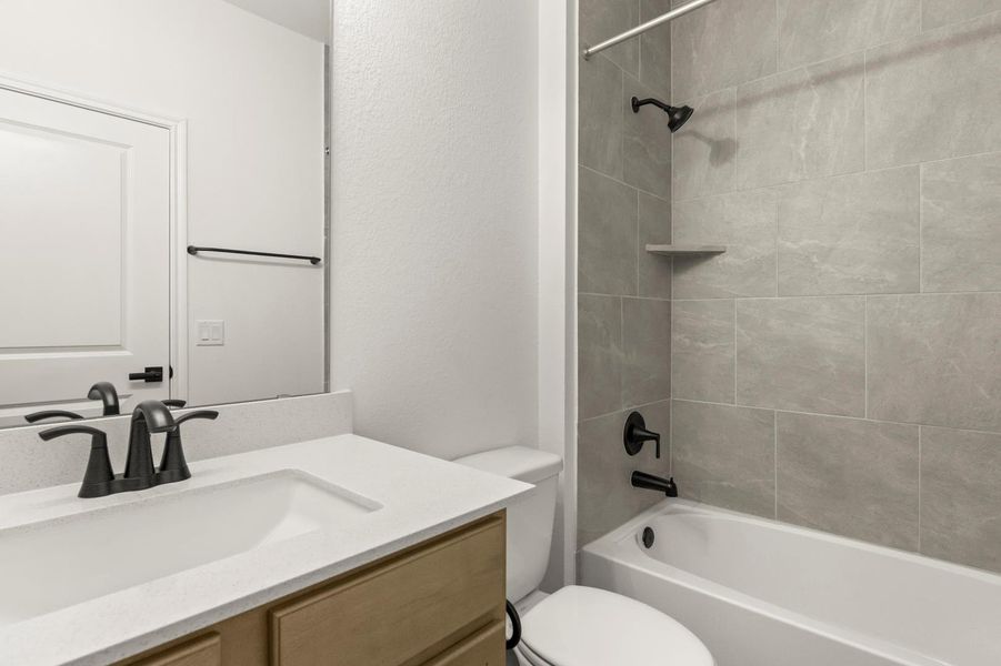 Bathroom featuring shower / bath combination, vanity, and a textured wall
