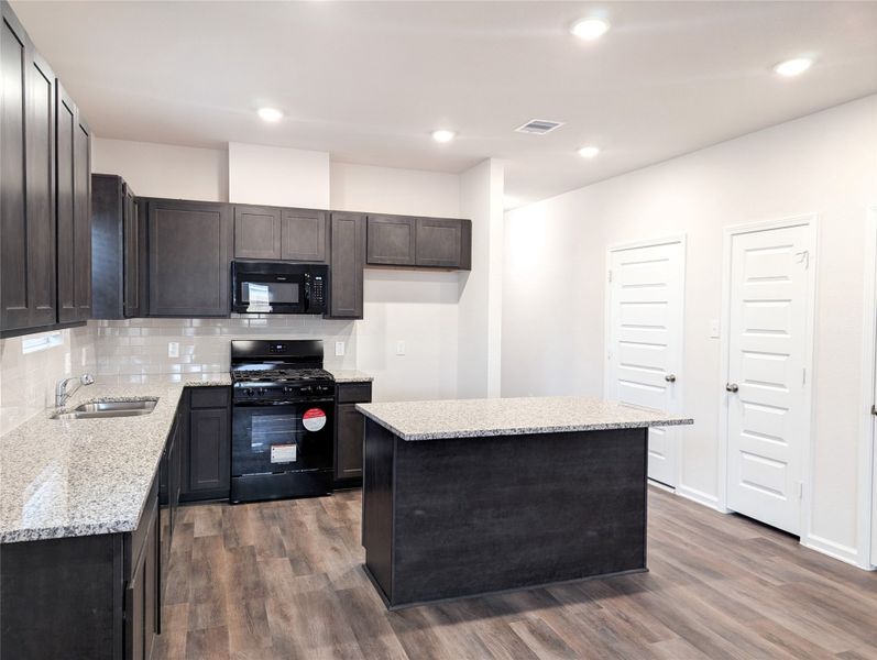 Kitchen has granite countertops, tile backsplash and lots of cabinet space