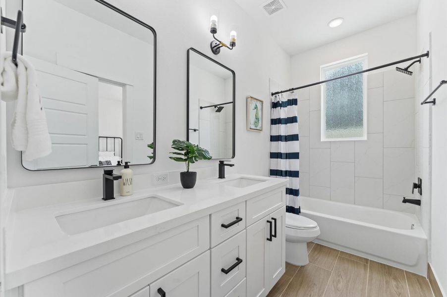 This thoughtfully designed Jack and Jill bathroom connects two bedrooms, offering a smart blend of privacy and shared convenience. Each room has its own entrance to the bathroom, which features dual vanities, a tub-shower combo, and modern fixtures that make morning routines a breeze. The layout allows both occupants to access the space independently, while locks on each door ensure personal privacy maximizing functionality without sacrificing style.