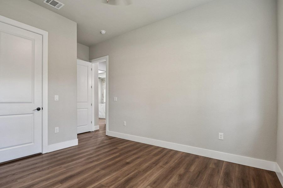 Unfurnished bedroom featuring baseboards and dark wood finished floors
