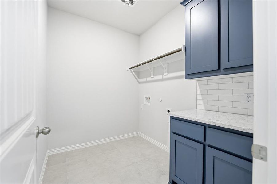 Laundry room with hookup for a gas dryer, electric dryer hookup, hookup for a washing machine, and cabinet space