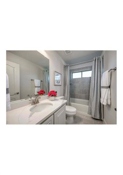 Full bathroom with toilet, shower / bath combo with shower curtain, vanity, and tile patterned flooring