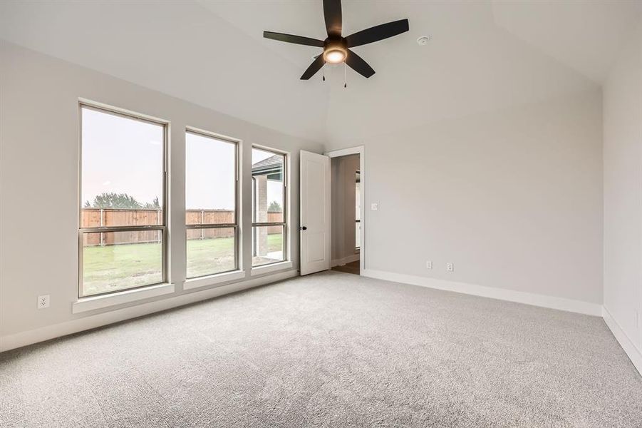 Spare room featuring baseboards, ceiling fan, vaulted ceiling, and light colored carpet Spare room featuring baseboards, ceiling fan, vaulted ceiling, and light colored carpet