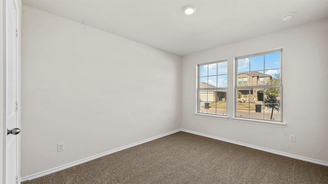 Unfurnished room featuring dark colored carpet and baseboards