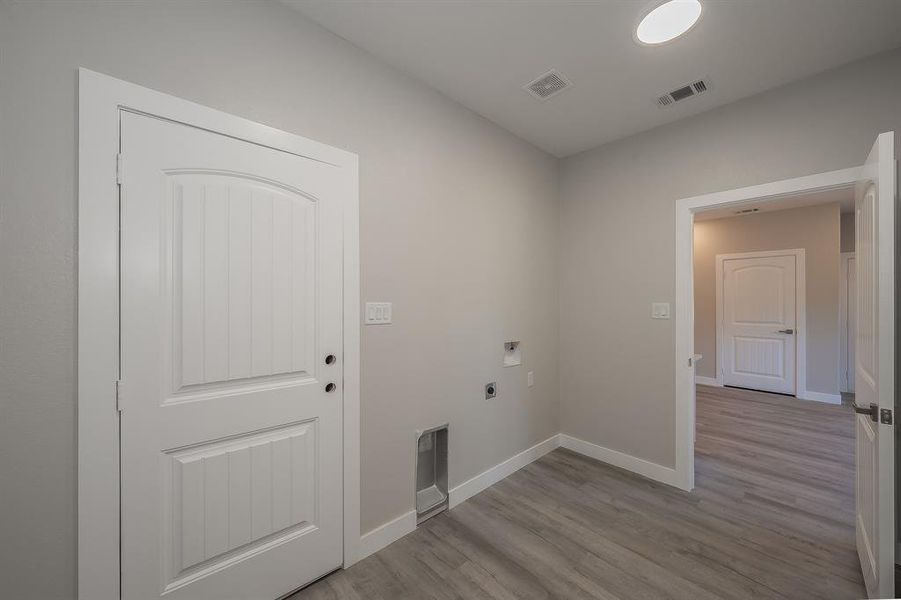 Laundry room featuring light wood finished floors and hookup for an electric dryer