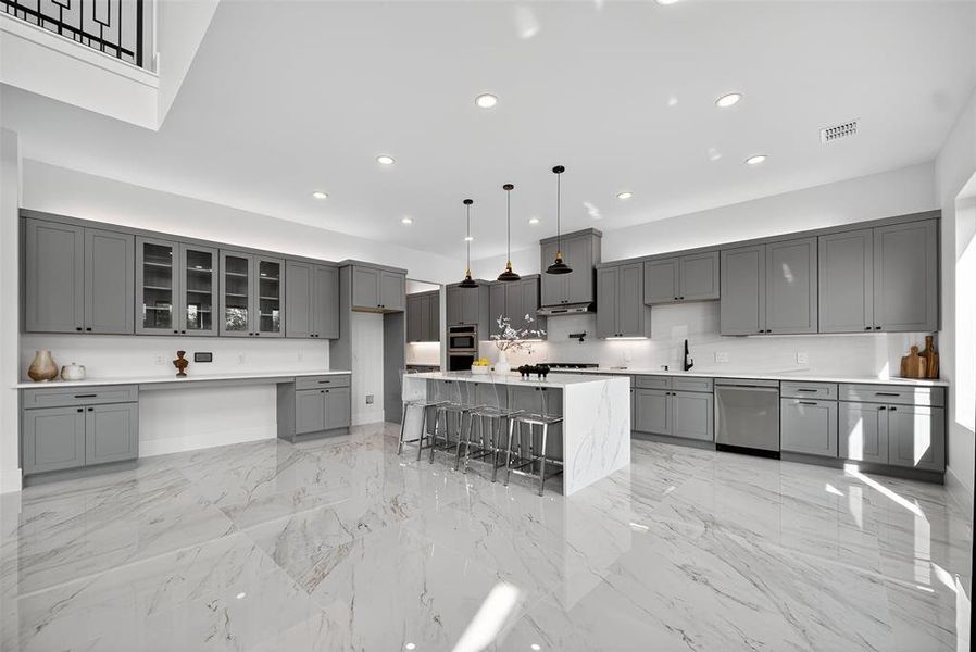 Kitchen with pendant lighting, gray cabinets, light stone countertops, a center island, and a kitchen breakfast bar