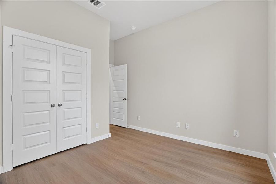 Light-toned wood-finish flooring complements the neutral wall color in this room