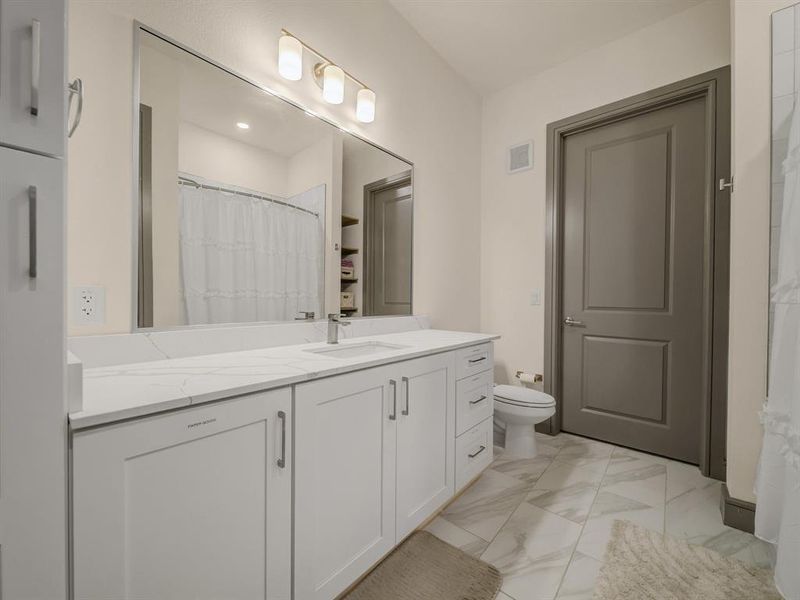 Full bathroom featuring vanity, light marble finish flooring, and a shower with shower curtain Full bathroom featuring vanity, light marble finish flooring, and a shower with shower curtain