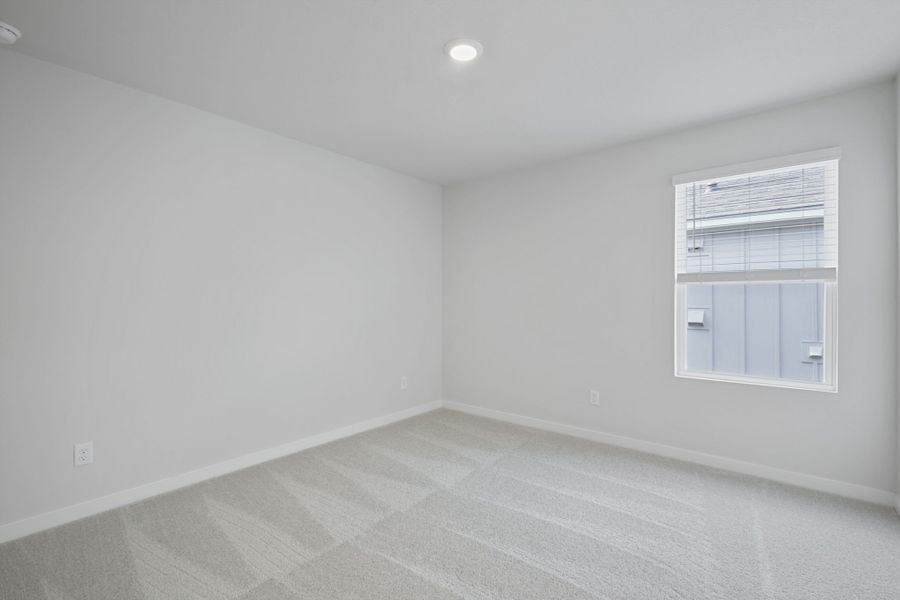 A room with a window and a white wall.