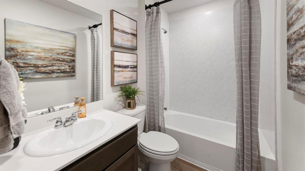 Bathroom featuring a single vanity with an integrated sink, chrome faucet, and a dark wood-finish cabinet Bathroom featuring a single vanity with an integrated sink, chrome faucet, and a dark wood-finish cabinet