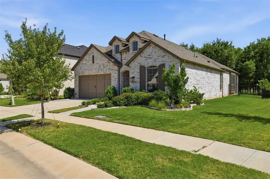 Brick exterior featuring a multi-gabled roof and an integrated two-car garage Brick exterior featuring a multi-gabled roof and an integrated two-car garage