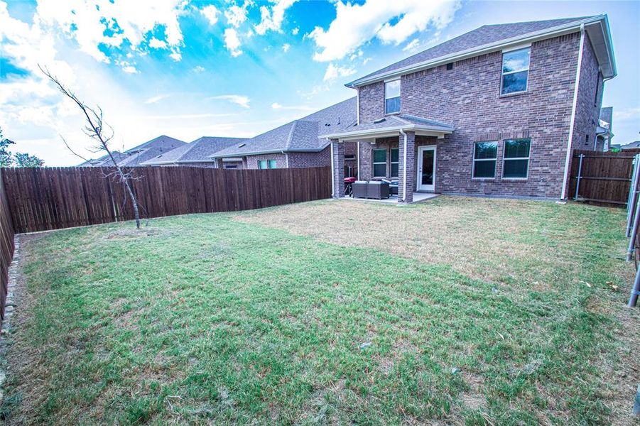 Rear view of house featuring a patio area, a fenced backyard, brick siding, an outdoor hangout area, and roof with shingles Rear view of house featuring a patio area, a fenced backyard, brick siding, an outdoor hangout area, and roof with shingles