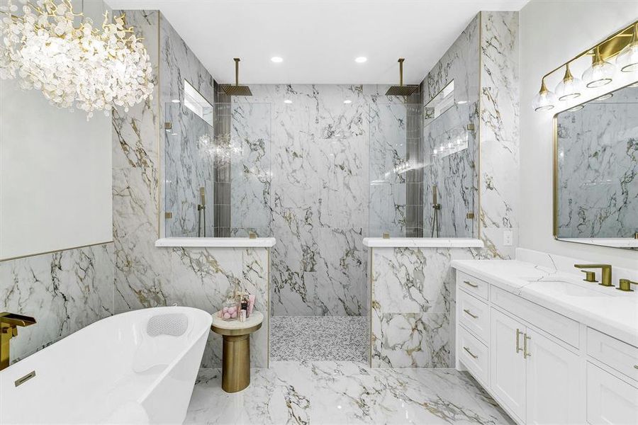 Bathroom featuring vanity, independent shower and bath, and a notable chandelier