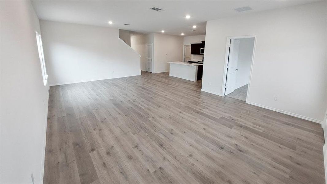 Unfurnished living room featuring light wood-style floors and recessed lighting Unfurnished living room featuring light wood-style floors and recessed lighting