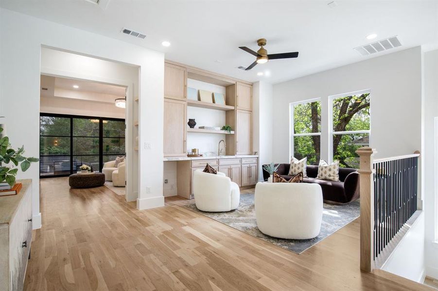 Expansive open-concept living area featuring light wood-finish flooring, recessed lighting, and a modern ceiling fan Expansive open-concept living area featuring light wood-finish flooring, recessed lighting, and a modern ceiling fan