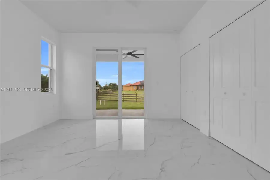 Primary bedroom with sliding glass doors to the lanai and dual closets.