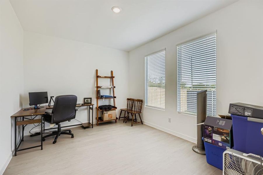 Office space featuring light wood-style flooring and recessed lighting