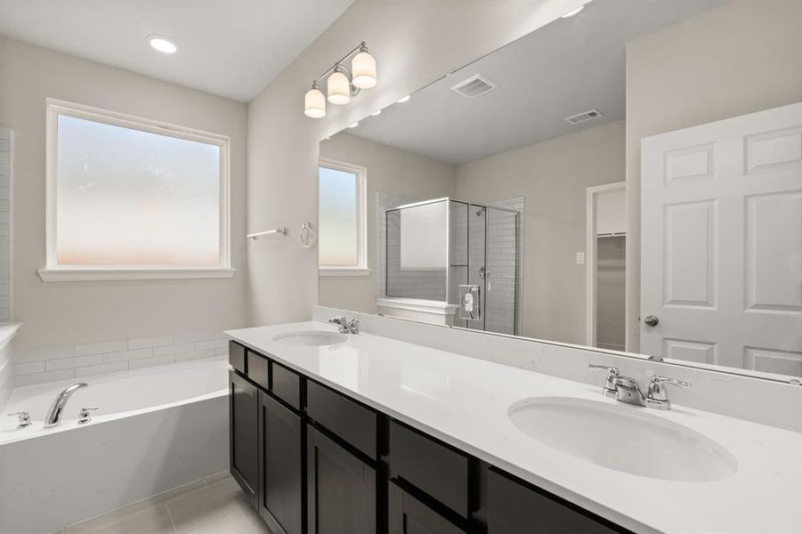 The en-suite bathroom offers a spa-like atmosphere with its elegant design, high end finishes, and tasteful lighting, creating a retreat within your own home.