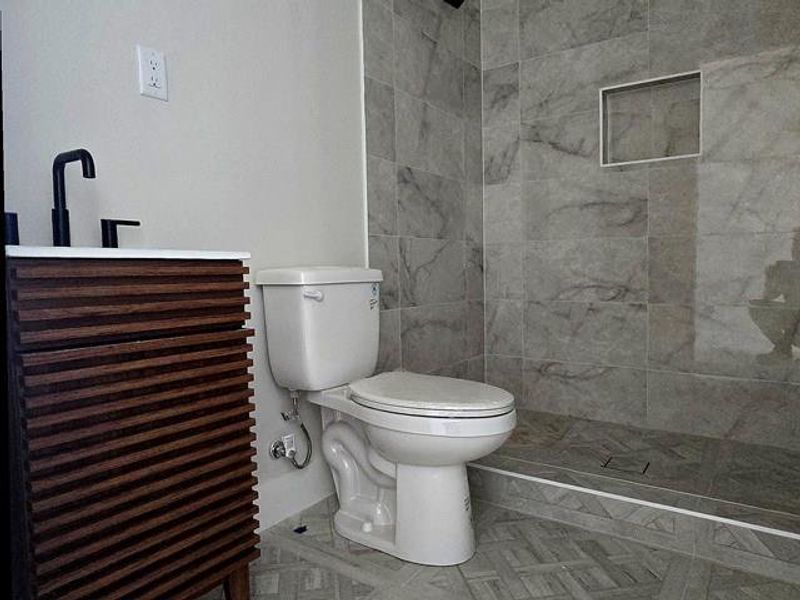 Bathroom with a tile shower and toilet