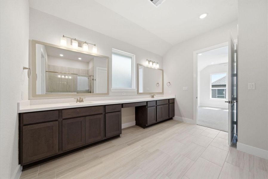 Luxurious primary bath with dual vanities, ample storage, and a dedicated vanity space.