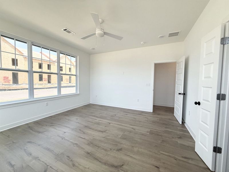 Unfurnished bedroom featuring ceiling fan and dark wood finished floors