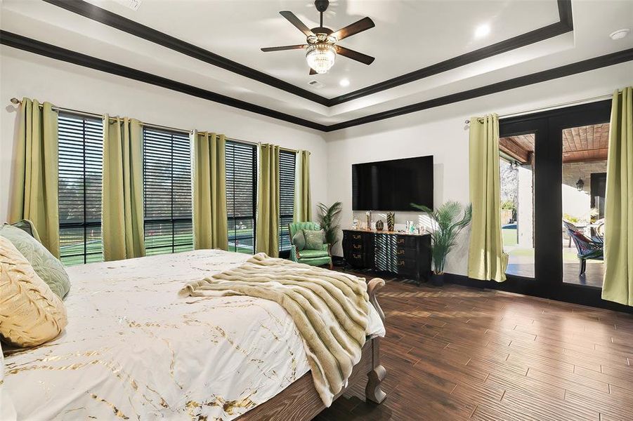 The primary bedroom has doors to the back patio and great views of the pool and backyard.