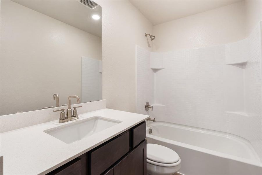 Full bathroom with washtub / shower combination, vanity, and toilet