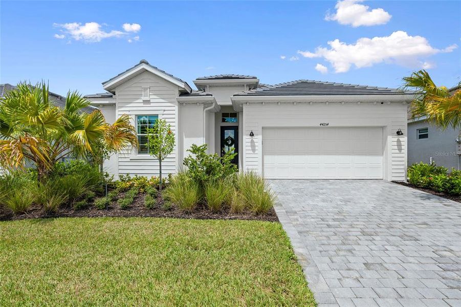 Front exterior of a new home in Webbs Reserve, Punta Gorda, FL, highlighting curb appeal (Image 1). Front exterior of a new home in Webbs Reserve, Punta Gorda, FL, highlighting curb appeal (Image 1).